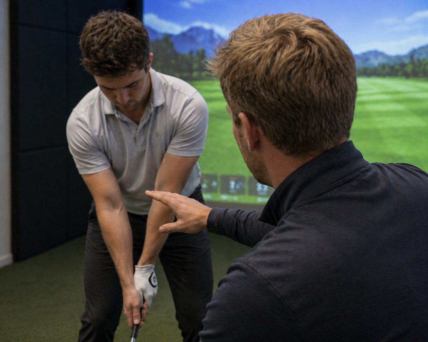 PGA professional giving a lesson in a simulator bay at The Perch